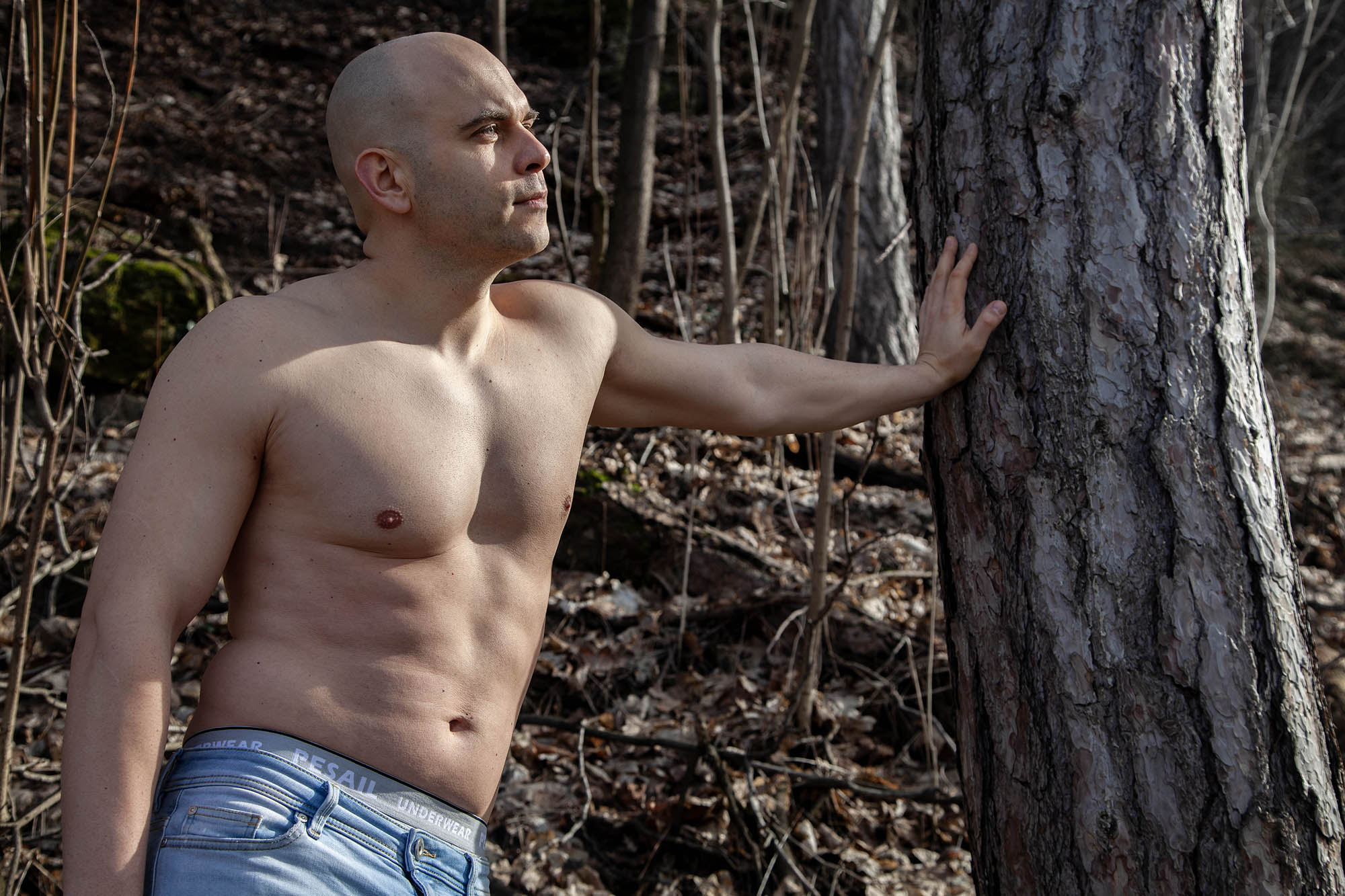 Portrait of Slovak man leading against a tree in the forest