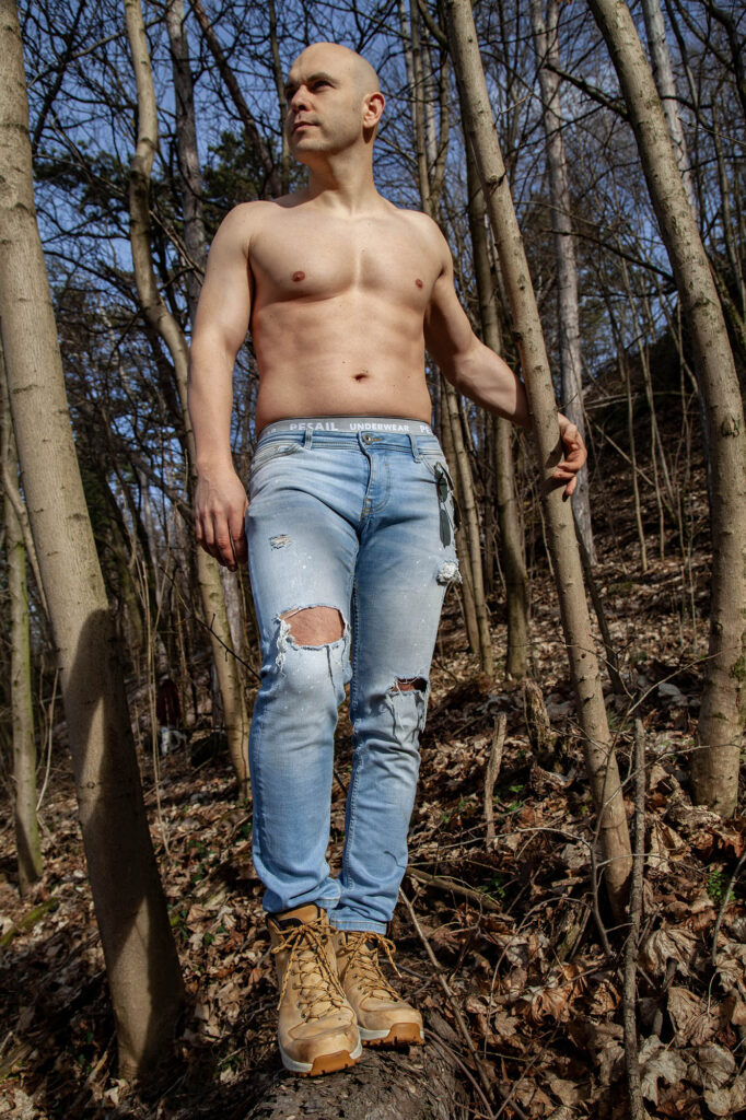Portrait of Slovak man standing on log in forest