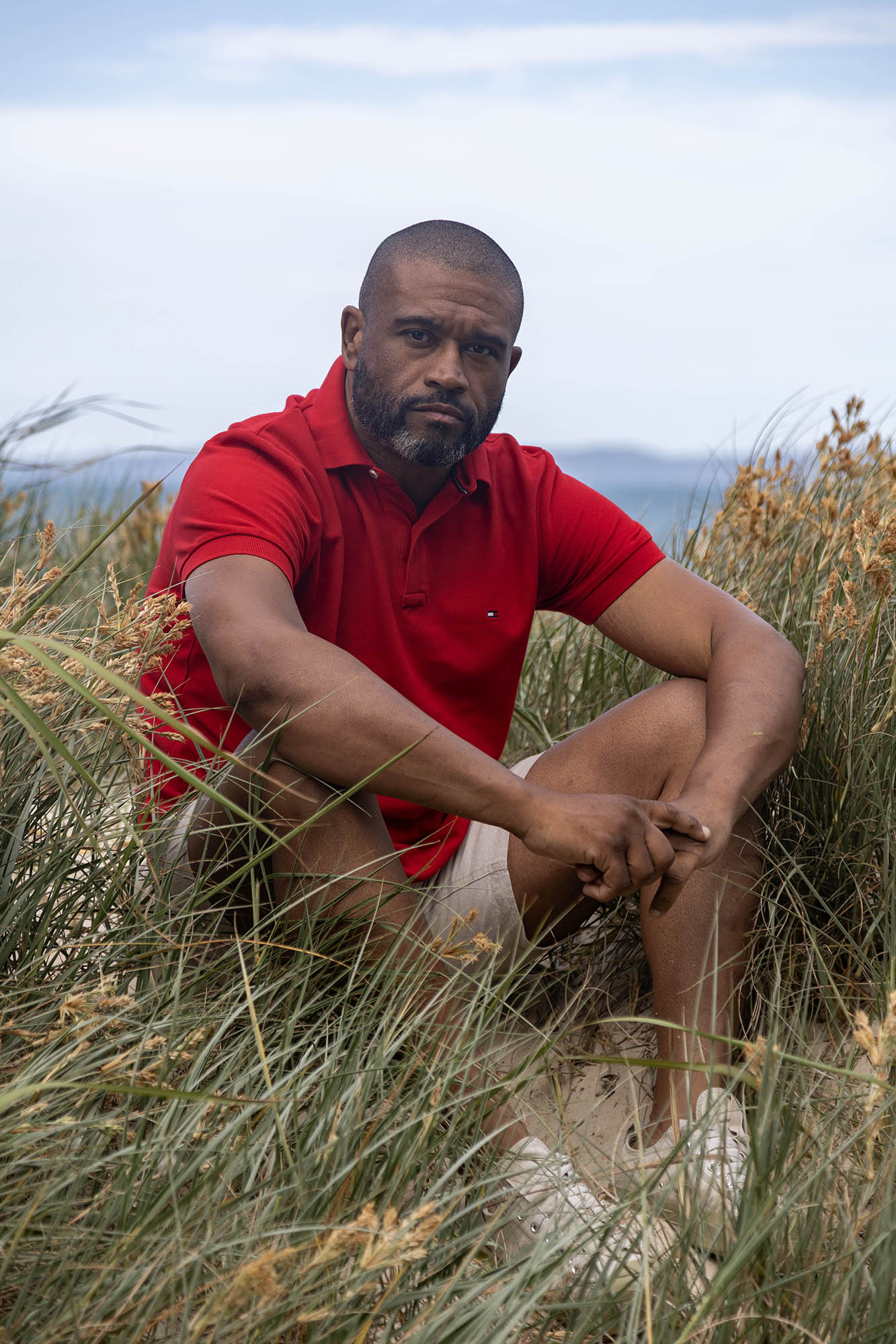 Kleber sitting among grass on beach, Bribie Island, Australia